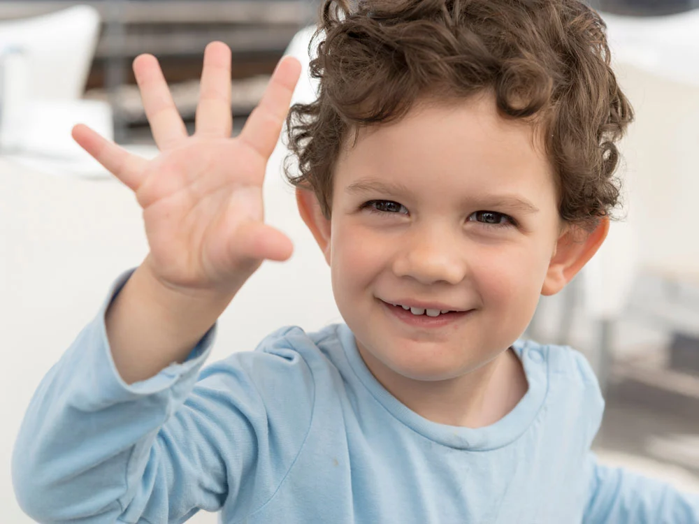 Smiling boy waving at camera