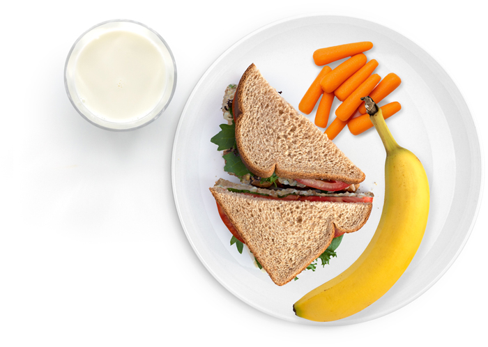 Sandwich, banana, carrots, and milk on a white plate.