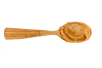 Wooden spoon with creamy peanut butter