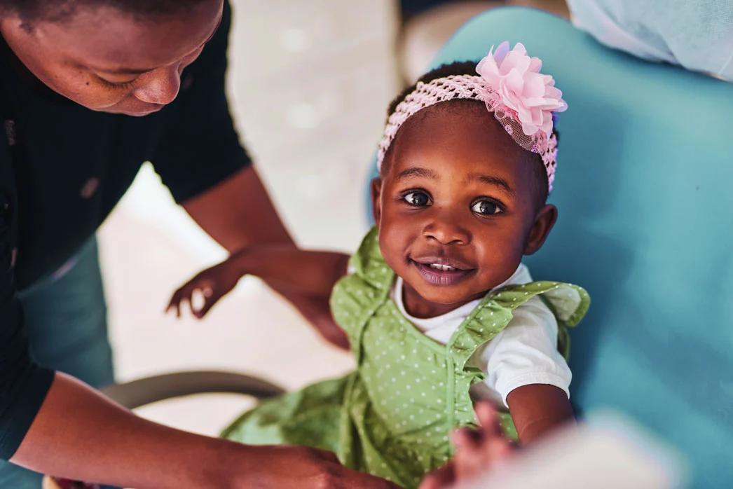 Smiling child in green dress with flower headband