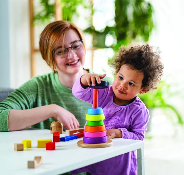 Mother and child playing with stacking toy