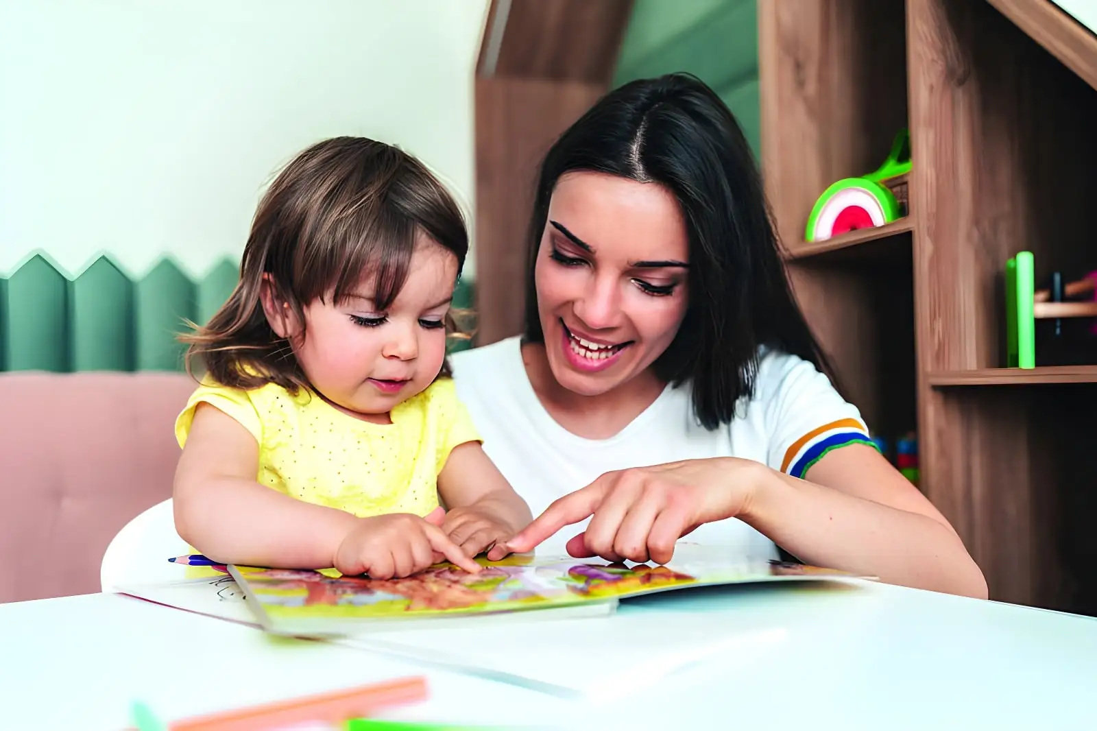 Mother and daughter reading book together happily
