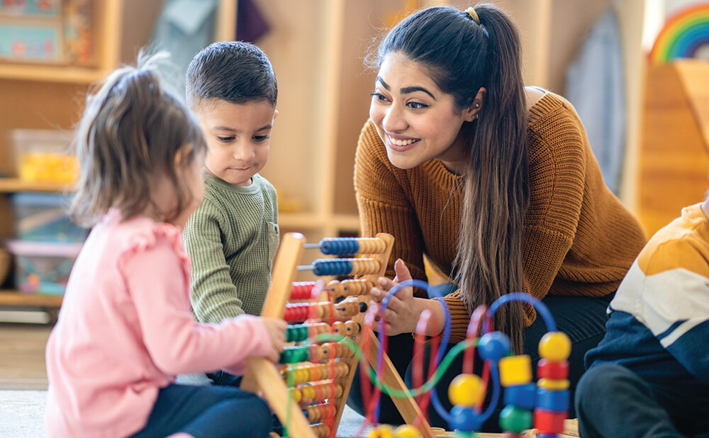 Teacher interacting with young children playing games